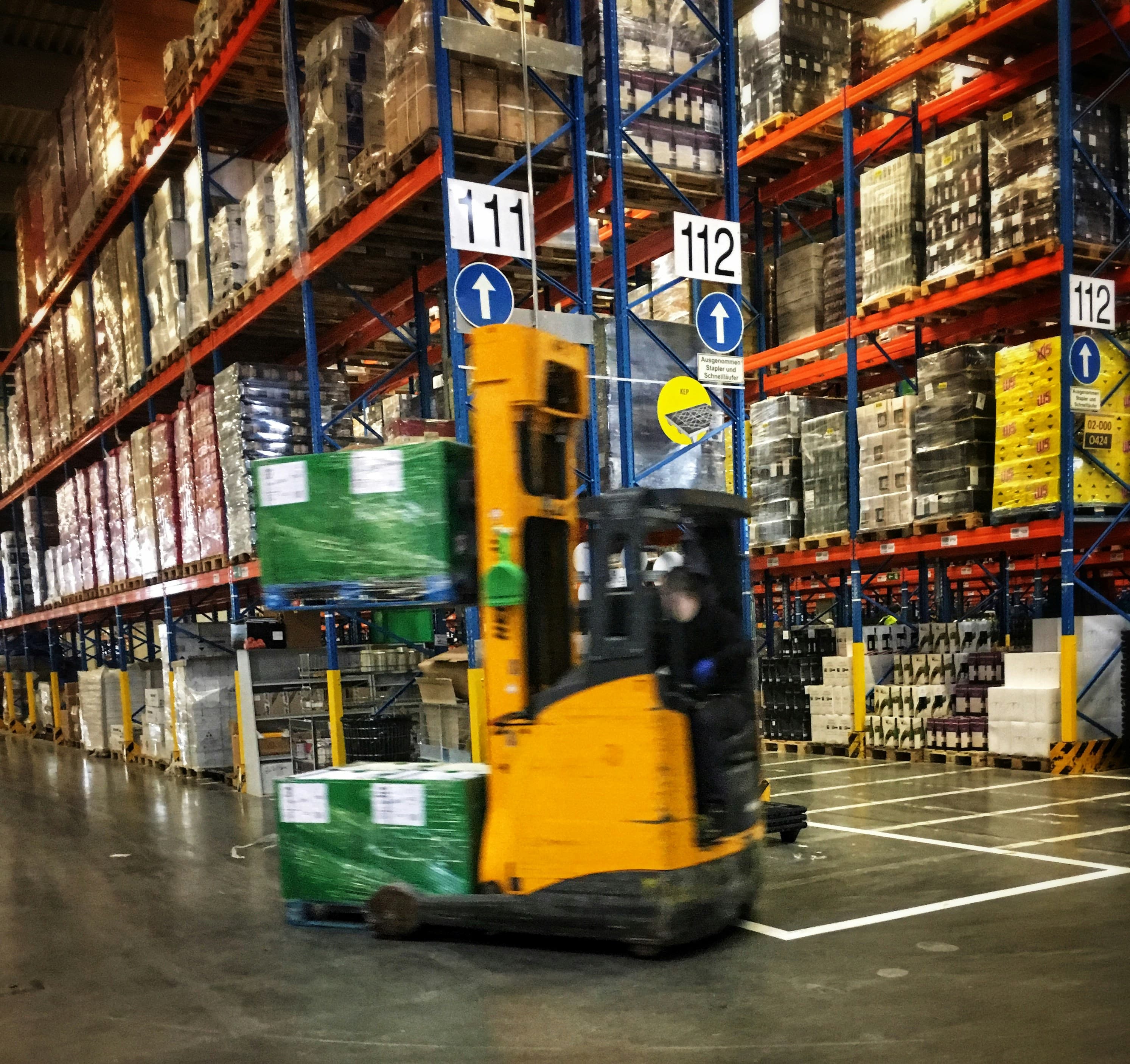 Forklift moving pallets inside a distribution warehouse